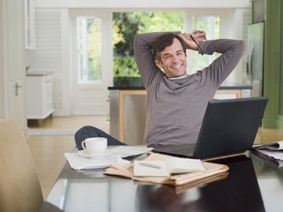 image of happy middle-aged business man which he uses as a home office